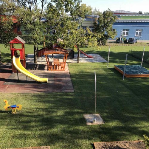 The well-maintained grounds of Tátika Kindergarten, featuring sandboxes and play equipment for the little ones.